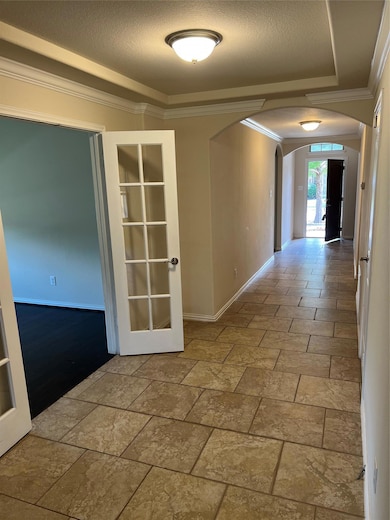 Hall featuring arched walkways, french doors, orn