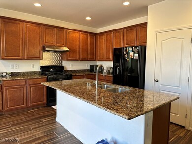 Kitchen featuring under cabinet range hood, black