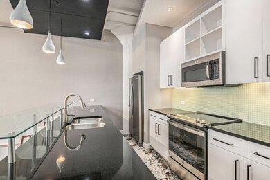 Kitchen featuring white cabinets, hanging light fi