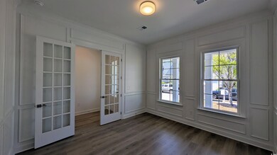 Doorway with french doors, visible vents, a decorative wall, and dark wood-style flooring