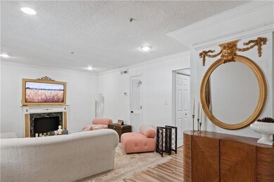 Living area with a textured ceiling, light wood-ty