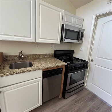 Kitchen with white cabinets, wood finished floors