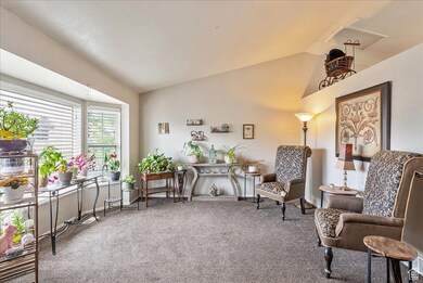 Living area featuring lofted ceiling and carpet