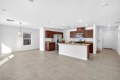 Kitchen featuring light tile patterned flooring, stainless steel appliances, recessed lighting, a center island with sink, and light stone countertops