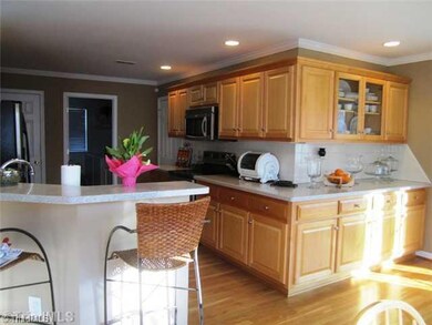 Kitchen. Kitchen eating bar and cabinets that wrap the corner into dining area. Solid surface countertops, tile backsplash