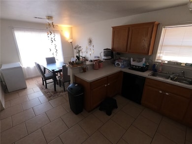 Kitchen with a peninsula, black dishwasher, light