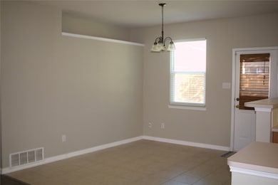 Unfurnished dining area featuring baseboards and a chandelier