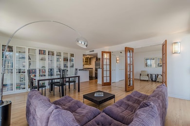 Living room with french doors and light wood-style floors