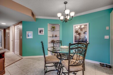 Tiled dining room featuring ornamental molding, a 