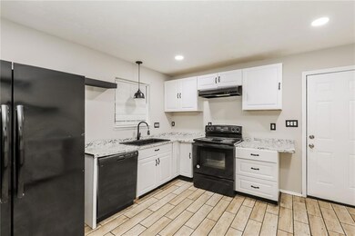 Kitchen featuring black appliances, a sink, under 