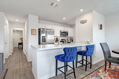 The modern kitchen offers white cabinetry, stainle