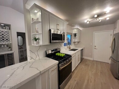 Kitchen featuring open shelves, stainless steel ap