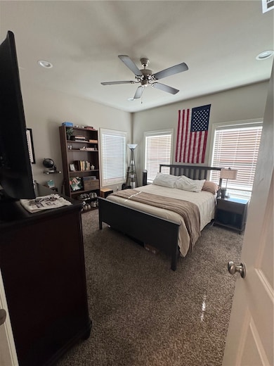Bedroom featuring dark carpet, recessed lighting, and a ceiling fan