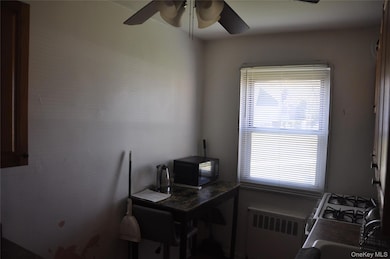 Office featuring radiator heating unit and a ceiling fan