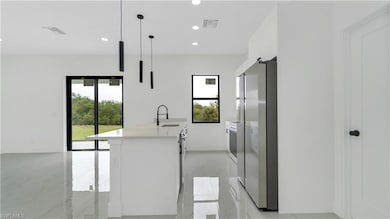 Kitchen featuring visible vents, freestanding refr