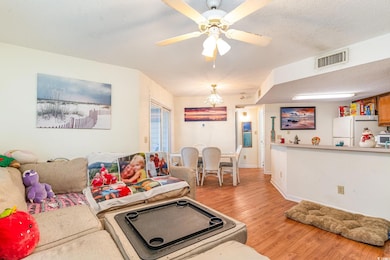 Living room with ceiling fan with notable chandeli