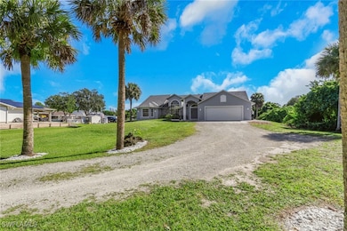 Ranch-style house featuring driveway, a front yard, and an attached garage