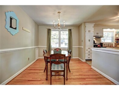 Dinning room has chair rail moldings, hardwoods, a