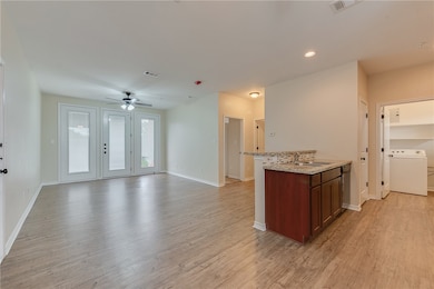 Kitchen with ceiling fan, light wood-style floorin