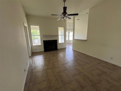 Unfurnished living room with tile patterned floors, a tile fireplace, and a ceiling fan