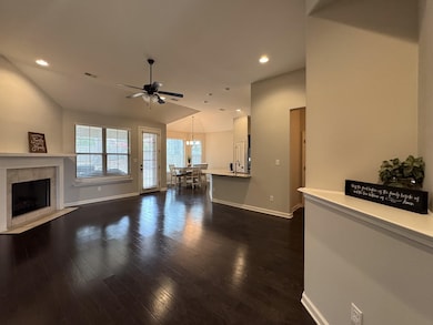 Living area with a tile fireplace, baseboards, rec