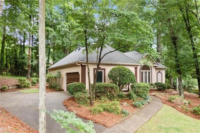 View of front of home with stucco siding, an attached garage, asphalt driveway, and roof with shingles