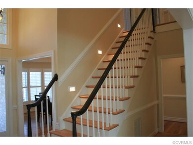 Two story foyer with exposed staircase leading to 