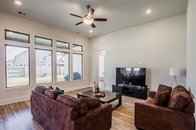 Gather the family and guests together in your lovely living room! Featuring recessed lighting, dark stained ceiling fan, custom paint, gorgeous wood floors, and large windows that provide plenty of natural lighting throughout the day.