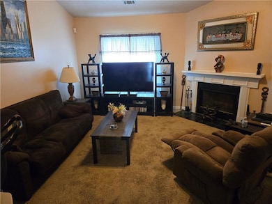Carpeted living area with a fireplace with flush hearth