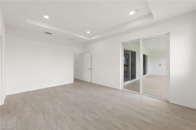Unfurnished room with a tray ceiling, visible vent