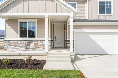 Entrance to property featuring board and batten siding, covered porch, concrete driveway, stone siding, and a shingled roof
