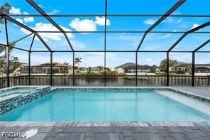 View of pool featuring glass enclosure, a water view, a sunroom, and a pool with connected hot tub