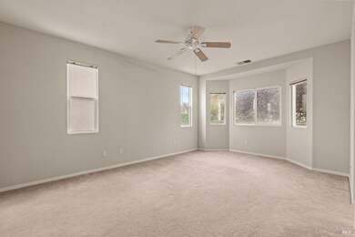 primary bedroom with ceiling fan and bay window