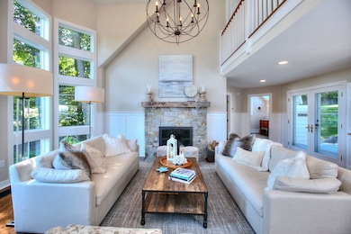 Formal Living Room w/ wood burning fireplace. Loads of light from fantastic wall of windows. Vaulted ceiling, interior upper balcony and access to back patio.