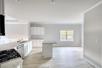 Kitchen with white cabinets, light stone counters,
