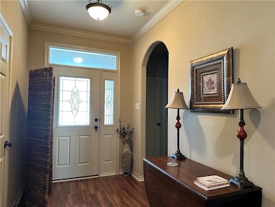 Entryway featuring arched walkways, dark wood-styl