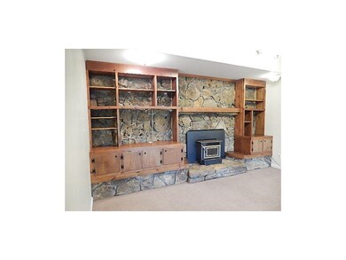 Wood burning fireplace surrounded by native rock