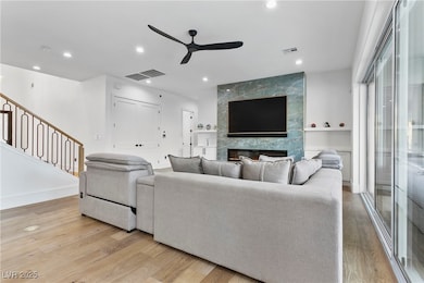 Living room with a tile fireplace, light hardwood