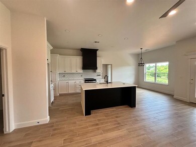 Kitchen featuring an island with sink, backsplash,