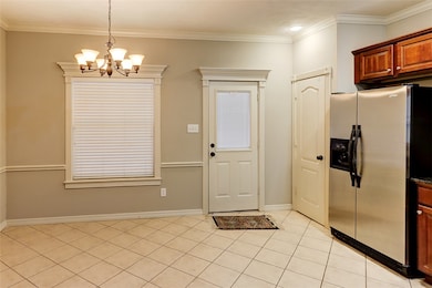 Kitchen with stainless steel fridge, a chandelier,