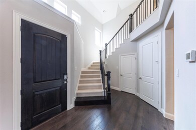 Foyer entrance with stairs, dark wood-style floori