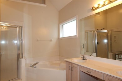 Bathroom featuring a stall shower, a garden tub, d