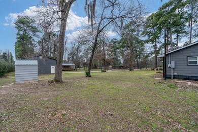 View from side of property looking at well house and workshop/garage
