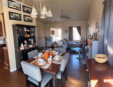 Dining room featuring dark wood-style floors, ceiling fan, and a chandelier