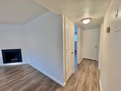 Corridor featuring a textured ceiling and light wood-type flooring
