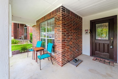 Property entrance with covered porch and brick siding