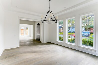 Impeccable formal dining exudes elegance featuring walls of floor-to-ceiling windows, gleaming oak hardwoods, and Circa Lighting chandelier. This dinging space is graciously sized to accommodate large furniture pieces and there is ample wall space for art.
