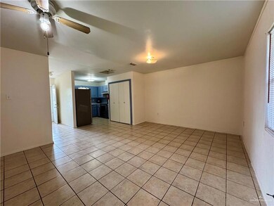 Empty room featuring light tile patterned flooring and a ceiling fan