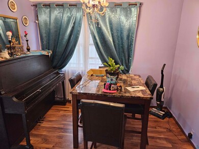 Dining area with dark wood-type flooring and a cha