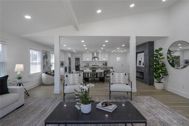 Living room featuring vaulted ceiling with beams, recessed lighting, and light wood-style floors